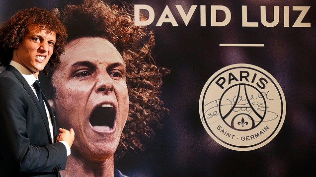 O jogador brasileiro David Luiz posa ao lado de uma foto sua no Paris Saint German nesta quinta-feira (7). O jogador assinou um contrato de cinco anos com o time francês