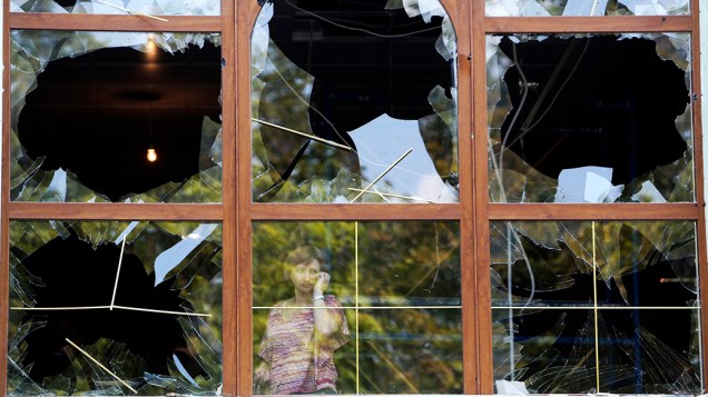 Uma mulher olha por uma janela destruída, após uma bombardeio de forças ucranianas em Donetsk segundo testemunhas locais