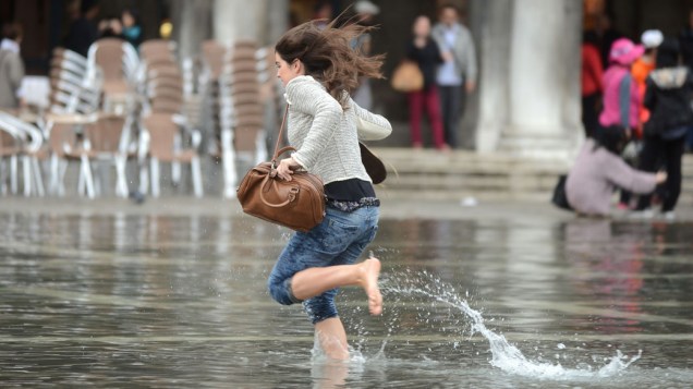 Mulher corre na praça de São Marcos, em Veneza