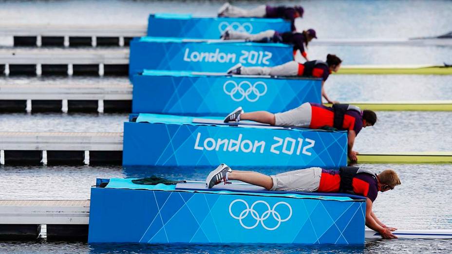 Oficiais de corrida seguram os barcos antes do início da prova de remo, no Eton Dorney, a oeste de Londres, em 30/07/2012