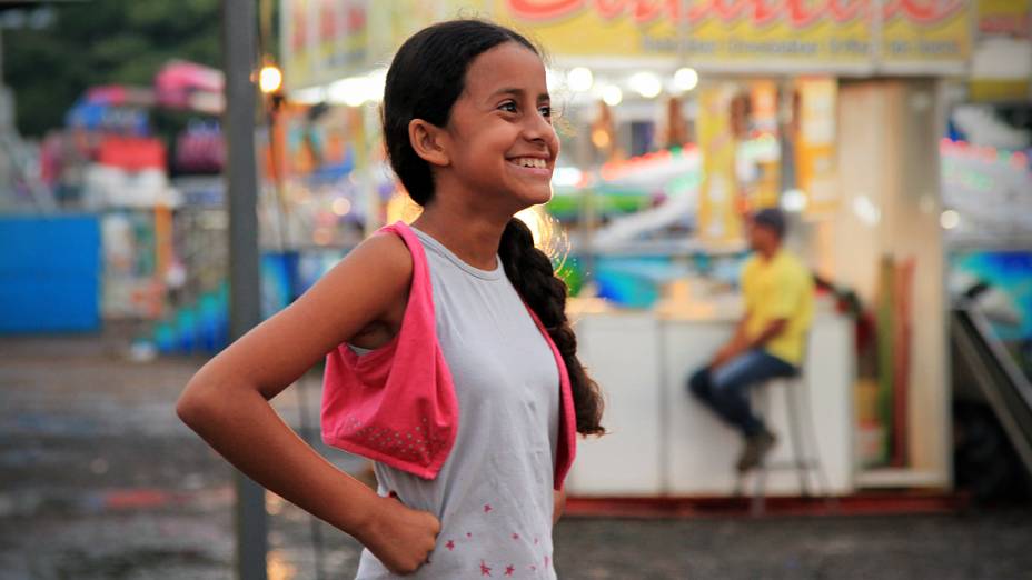 Menina em parque de diversões montado para festa de peão, em Londrina, no Paraná