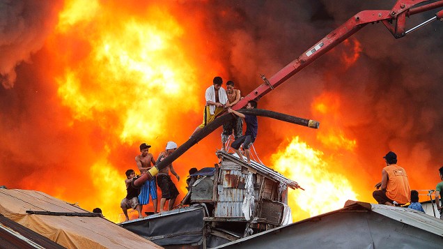 Moradores tentam apagar incêndio em favela de Manila, pelo menos 1.000 casas foram destruídas