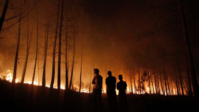 Moradores observam incêndio que já destruiu mais de 3.000 hectares em Povoa de Calde, em Portugal