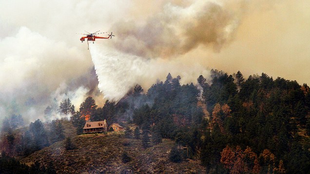 Árvores em chamas próximo de uma casa no High Park, no estado do Colorado, EUA. Segundo informações do xerife local, o fogo consumiu 37 mil hectares de mata na região
