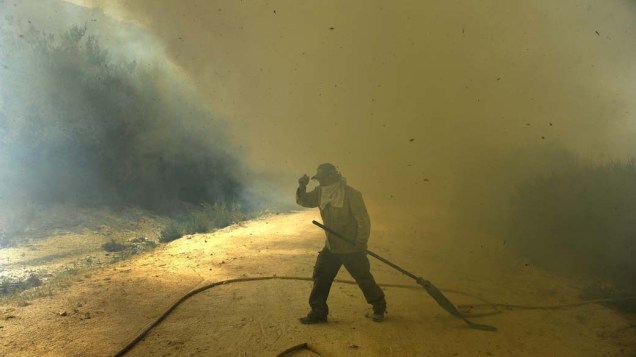 Bombeiro caminha em área incendiada no parque natural da Serra do Gerês em Lindoso, Portugal. Cerca de 650 profissionais trabalham para conter o fogo que se espalha no país desde a semana passada