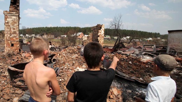 Garotos russos olham os restos de uma residência queimada, em Voronezh. O serviço secreto de pesquisas nuclear da Rússia deixou de trabalhar com materiais radioativos e explosivos depois que incêndios devastaram a região