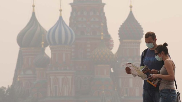Turistas utilizaram máscaras para proteger-se da fumaça em frente à Catedral de São Basílio na Praça Vermelha em Moscou, na Rússia