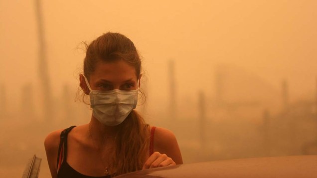 No vilareja de Mokhovoye, a 130 km de Moscou, mulher usa máscara para se proteger da fumaça dos incêndios
