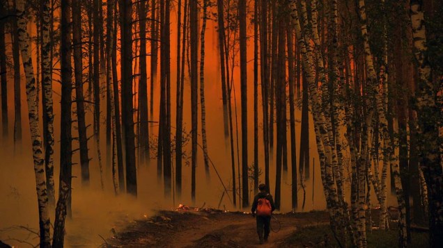 Homem caminha em floresta em chamas próxima ao vilarejo de Golovanovo, na Rússia