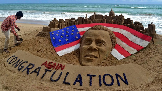 Artista indiano faz os retoques finais em escultura de areia feita em homenagem ao presidente reeleito dos Estados Unidos, Barack Obama, na praia de Puri, na Índia