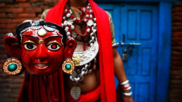Dançarino posa com uma máscara após se apresentar no festival hindu Indra Jatra, em Catmandu, Nepal