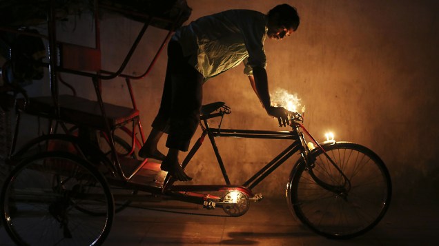 Indiano coloca velas em sua bicicleta para obter boa sorte e fortuna durante o festival Diwali, em Nova Délhi