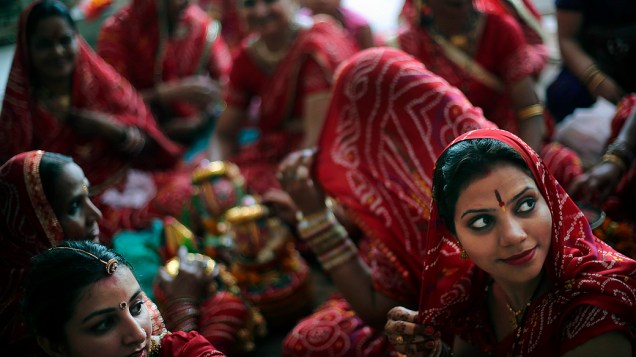 Mulheres hindus com vestidos coloridos como parte do festival Dussehra Ganga em um templo em Nova Déli, Índia