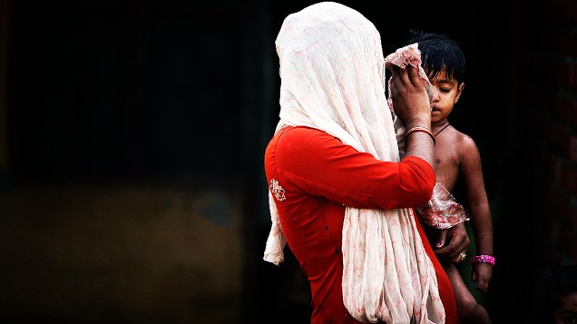Mulher refugiada do paquistão cuida de menina numa favela de Jammu, na Índia
