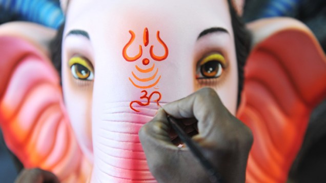 Artesão indiano aplica toques finais a uma imagem do deus hindu Ganesha em sua oficina em Hyderabad