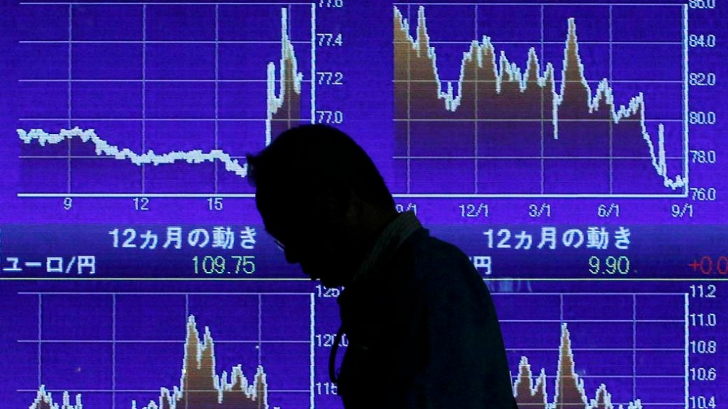 Homem passa em frente ao painel da bolsa de ações de Tóquio, no Japão