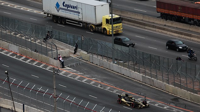 Carros e caminhões na Marginal Tietê passam junto a pista do sambódromo do Anhembi durante treino livre da fórmula Indy