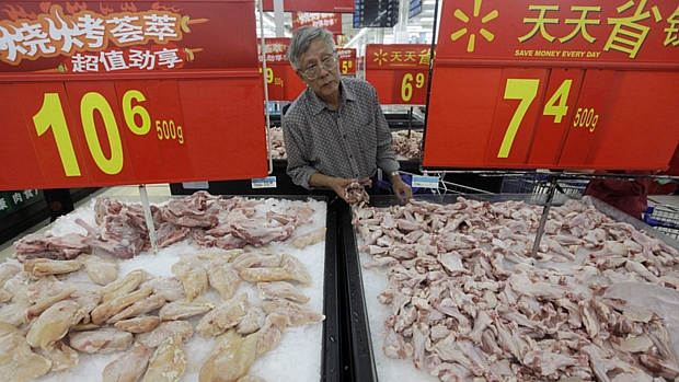 Consumidor confere preço do frango em supermercado da cidade chinesa de Wuhan: queda no grupo Alimentação ajudou a reduzir inflação do país em agosto