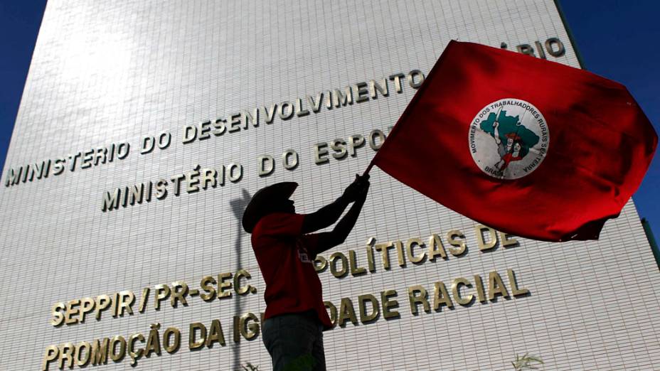 Integrante do MST com a bandeira do movimento durante ocupação do prédio do Ministério do Desenvolvimento Agrário em Brasília