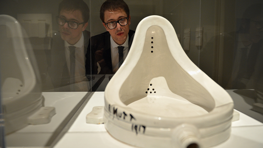 Um visitante observa a mais famosa obra do artista francês, Marcel Duchamp, intitulada 'A Fonte', na Galeria Nacional de Arte Moderna, em Edimburgo, na Escócia