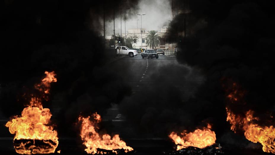 Pneus são queimados em uma estrada durante confrontos entre manifestantes e policiais do Bahrein após um protesto contra a realização do GP de Fórmula 1 no país