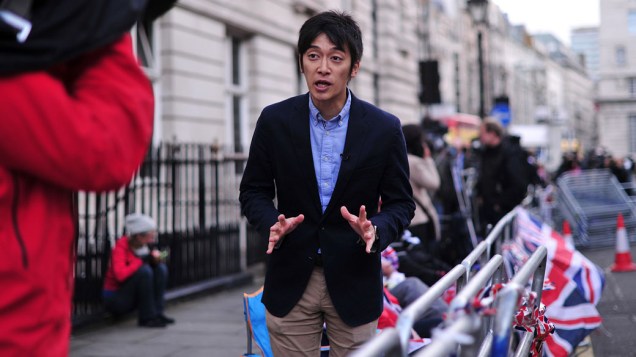 Jornalista japonês aguarda do lado de fora do Palácio de St. James, no centro de Londres, pelo batizado do príncipe George, na Inglaterra