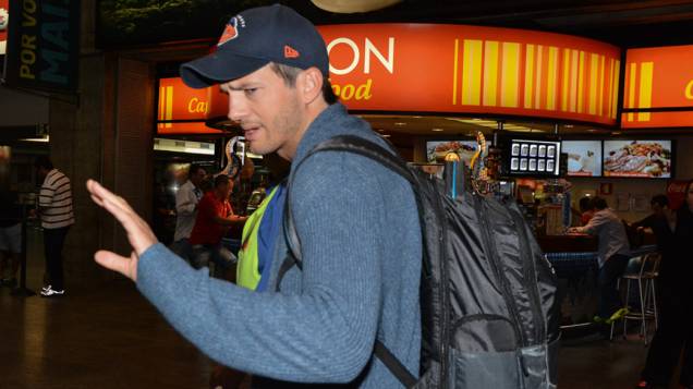 Ashton Kutcher acena para fãs no Aeroporto Internacional de Guarulhos, em São Paulo