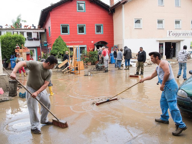Moradores da cidade de Triftern ajudam a limpar a lama das ruas causada pelas fortes chuvas que atingiram a região, na Alemanha