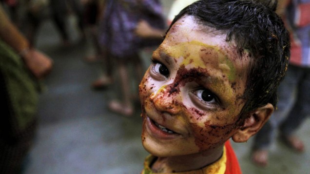Menino com rosto pintado participa do Holi, o Festival das Cores, em Mumbai, Índia