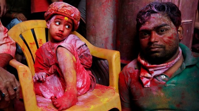 Criança coberta de tinta colorida no templo Bihari Banke, dedicado a divindade hindu, Lord Krishna, durante as celebrações do Festival Holi em Vrindavan, Índia