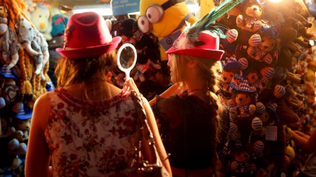 Mulheres experimentam chapéus em um quiosque durante o 180° Oktoberfest em Munique, na Alemanha