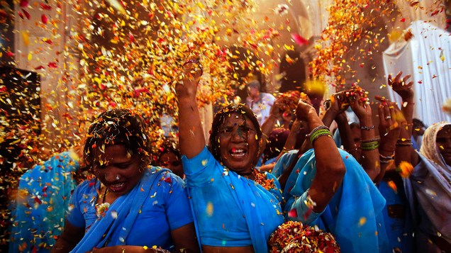 Mulheres jogam flores durante o Festival Holi, em Vrindavan, Índia