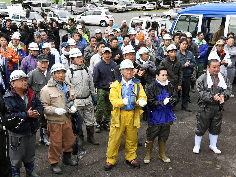 Membros da equipe de busca comemoram, após menino de 7 anos que estava desaparecido desde 28 de maio, ser encontrado vivo, no Japão