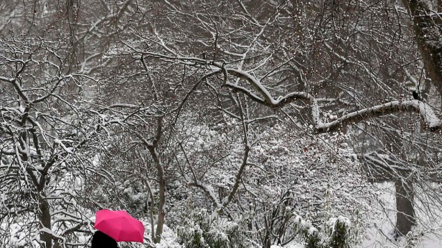 Mulher caminha na neve em St James Park no centro de Londres nesta segunda-feira (21)