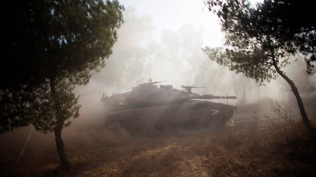 Tanque israelense realiza manobra após o fim de uma trégua humanitária de cinco horas, perto da fronteira com a Faixa de Gaza - 17/07/2014