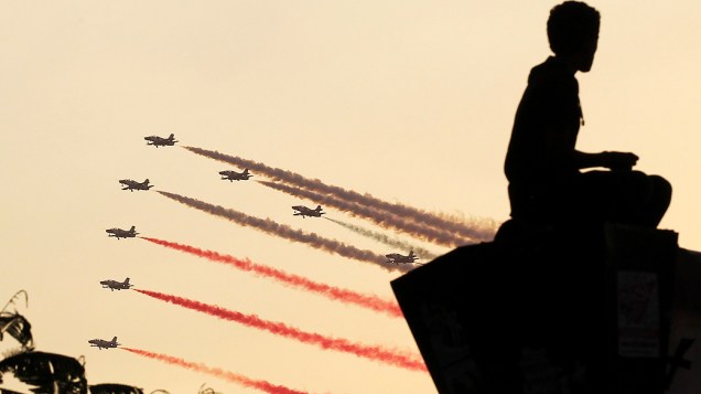 Silhueta de um homem ao pôr do sol enquanto jatos militares voam em formação sobre a praça Tahrir, no Cairo, nesta quinta-feira (4)
