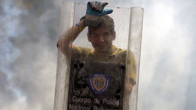Estudante venezuelano usou escudo da polícia durante protesto contra o governo do presidente Nicolás Maduro, em Caracas