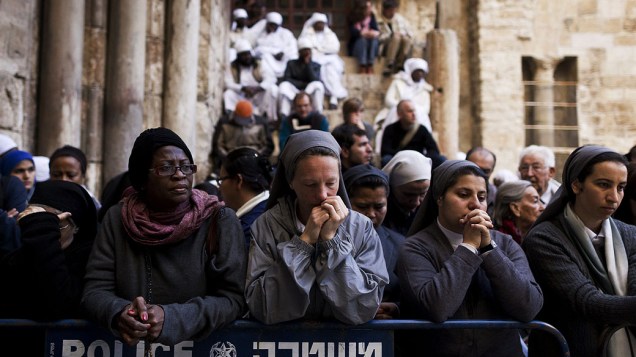 Fiéis oram enquanto aguardam abertura da Igreja do Santo Sepulcro, na cidade velha de Jerusalém, em Israel, na celebração da Sexta-feira Santa
