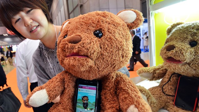 Funcionária da empresa japonesa Cube exibe o "Cocolo Bear", um robô em forma de urso de pelúcia pode falar até 600 palavras por meio do iPhone instalado no seu corpo