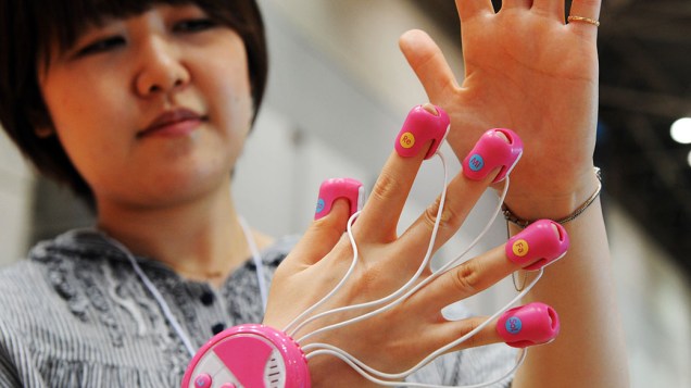  <br><br>  Funcionária da empresa japonesa Cube exibe o brinquedo "Yube de Piano", que tem pequenos sensores de toque na ponta de cada dedo que soam como um piano <br><br>   