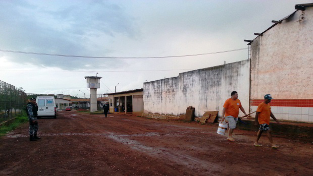 Detentos que trabalham na limpeza do Presídio São Luís I caminham sob olhar de PM do Batalhão de Choque