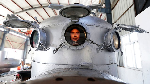 Zhang Wuyi, senta em seu novo submarino, construído em Wuhan, na China. Zhang é um inventor amador e já fez sete miniaturas de submarinos. Um deles chegou a ser vendido a um empresário local por cerca de R$ 30 mil