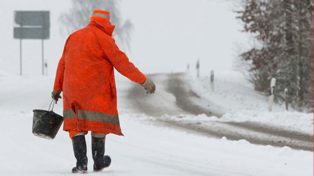 Em Lotzbach, na Alemanha, trabalhador joga sal na neve para derreter o gelo da estrada