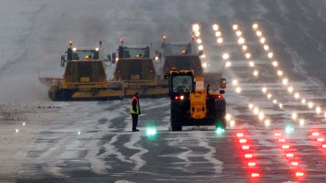 Tratores limpam a pista do aeroporto de Edimburgo, na Escócia