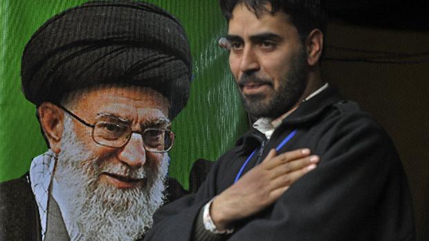 Iraniano bate no peito ao lado de retrato do aiatolá supremo Khamenei