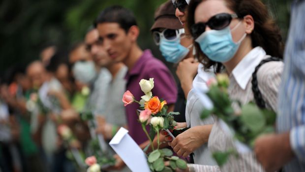 Manifestantes iranianos seguram flores em protesto pacífico do Programa de Desenvolvimento da Organização das Nações Unidas na Malásia, nesta quarta