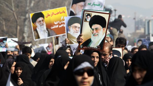 Milhares de manifestantes pró-governo seguram foto do líder supremo Ayatollah Ali Khamenei e pedem que o opositor Mehdi Karroubi seja enforcado por sua traição, em 18 de fevereiro de 2011, em Teerã