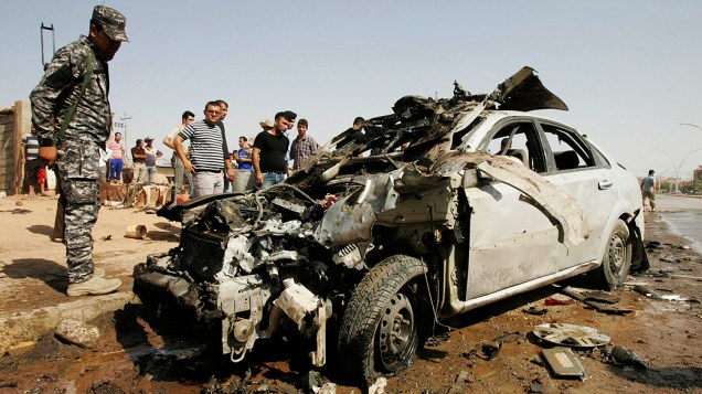 Policial observa carro em Kirkuk; série de atendados a bomba deixaram ao menos 50 mortos no Iraque
