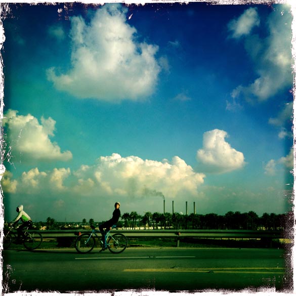Foto tirada com um IPhone, mostra homem andando de bicicleta, na capital iraquiana Bagdá