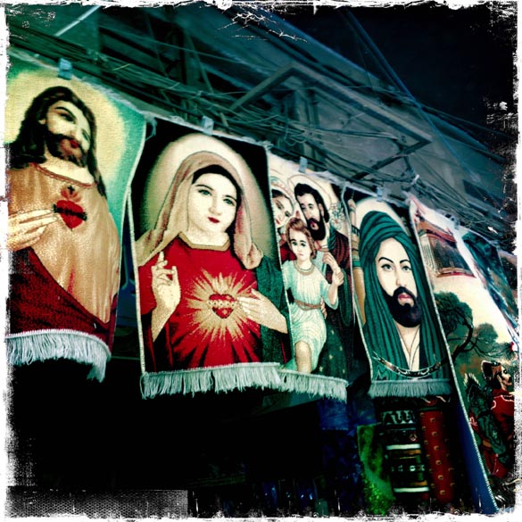 Tapetes com figuras religiosas cristãs e muçulmanas, à venda em uma loja na capital iraquiana Bagdá